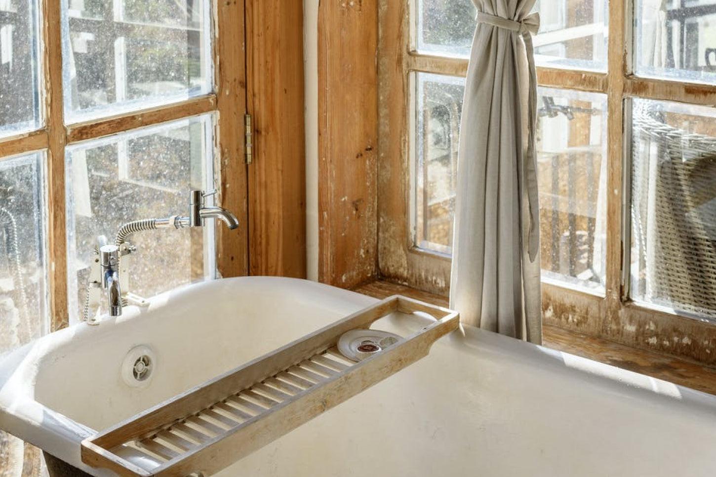 Man and Woman Couple swimming, relaxing and having fun in an outdoor hot tub jacuzzi pool in a sunny, snowy nature forest.